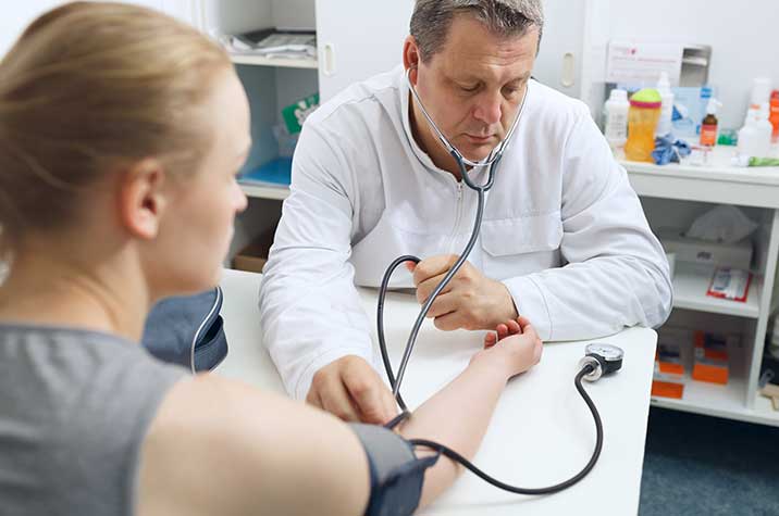 Arzt misst Blutdruck bei Frau