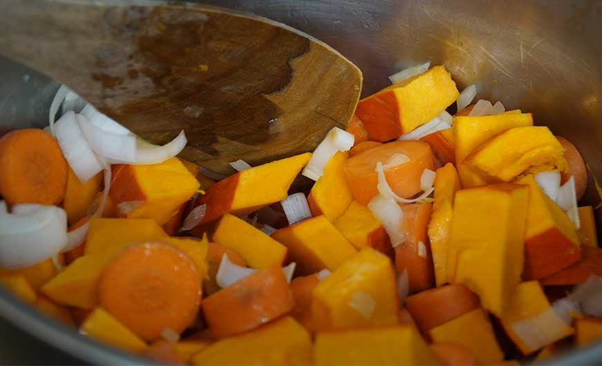 zwiebel, Kuerbis und Karottenstuecke im topf